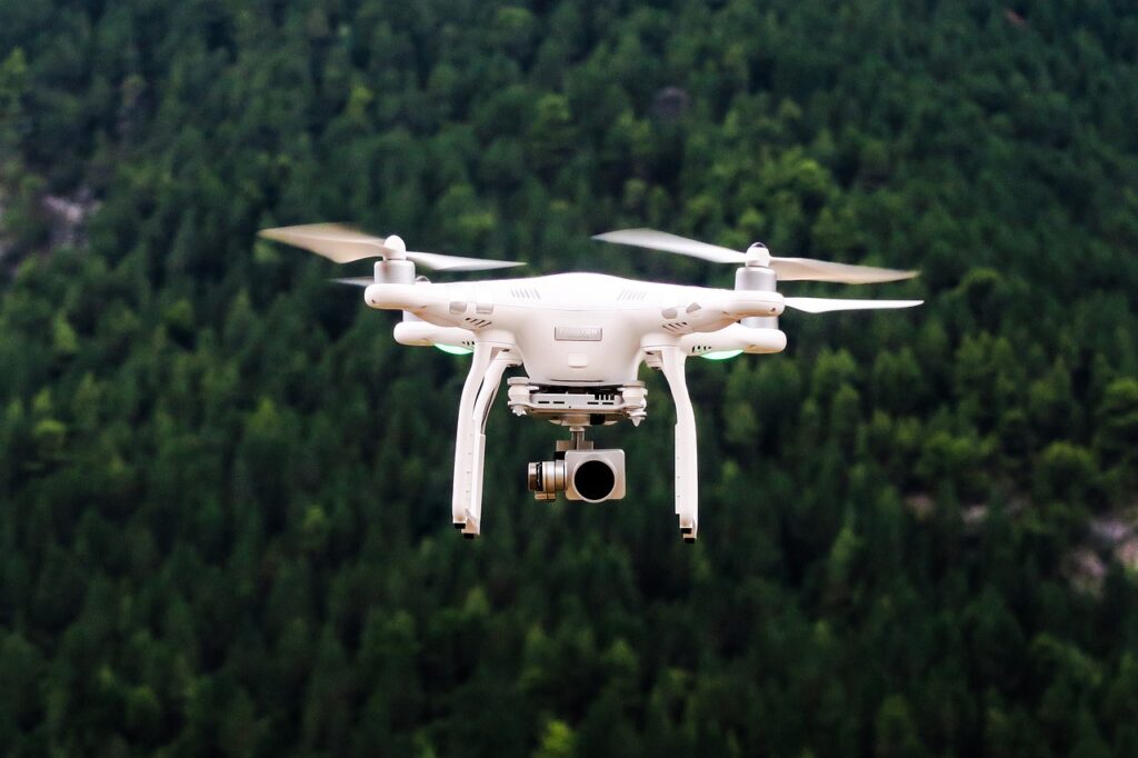 Drone bianco in volo sopra una foresta