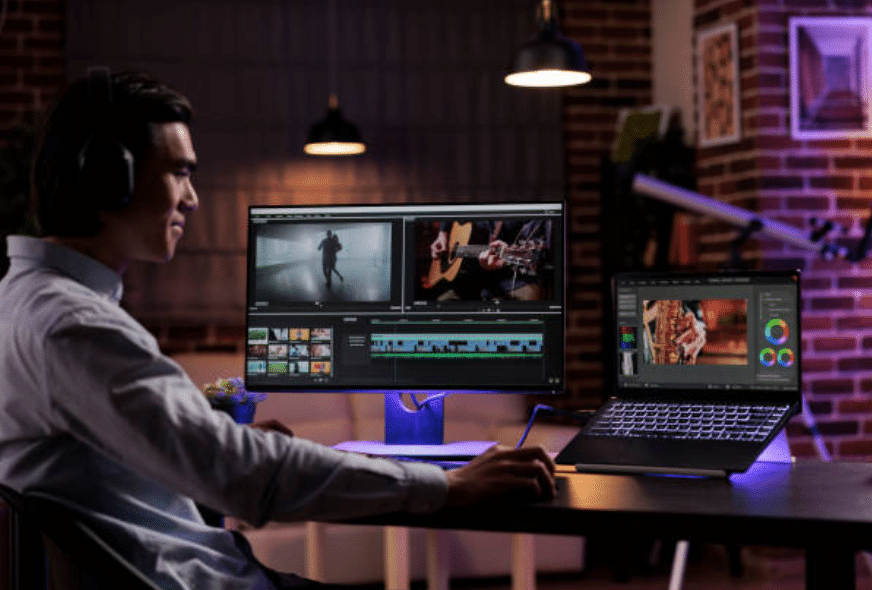 Giovane uomo lavora su PC con tre schermi